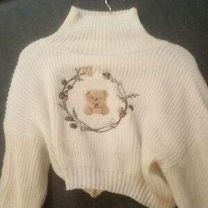 Crop sweater with turtleneck and long sleeves and a teddy bear in the middle